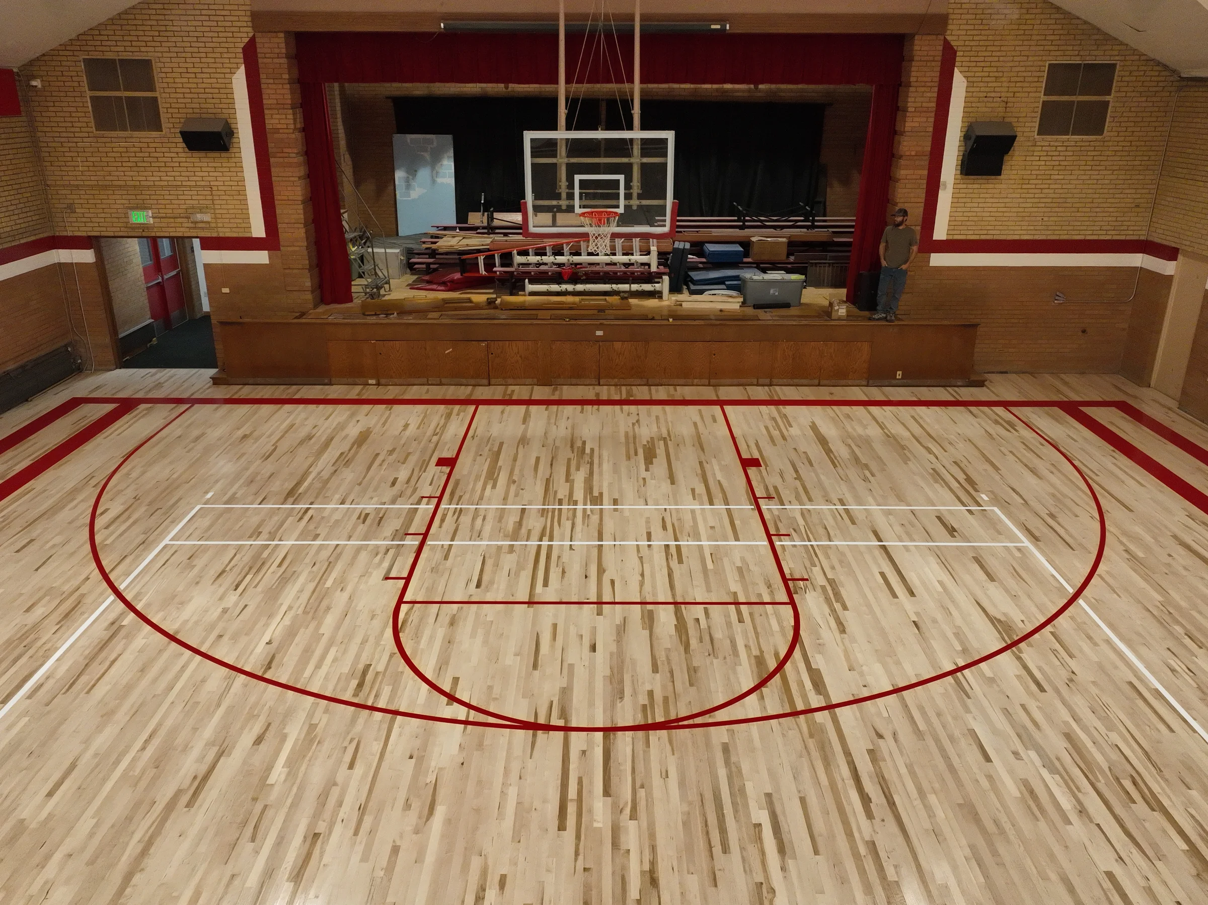 Elevated view of the finished gymnasium floor, court lines, and stage