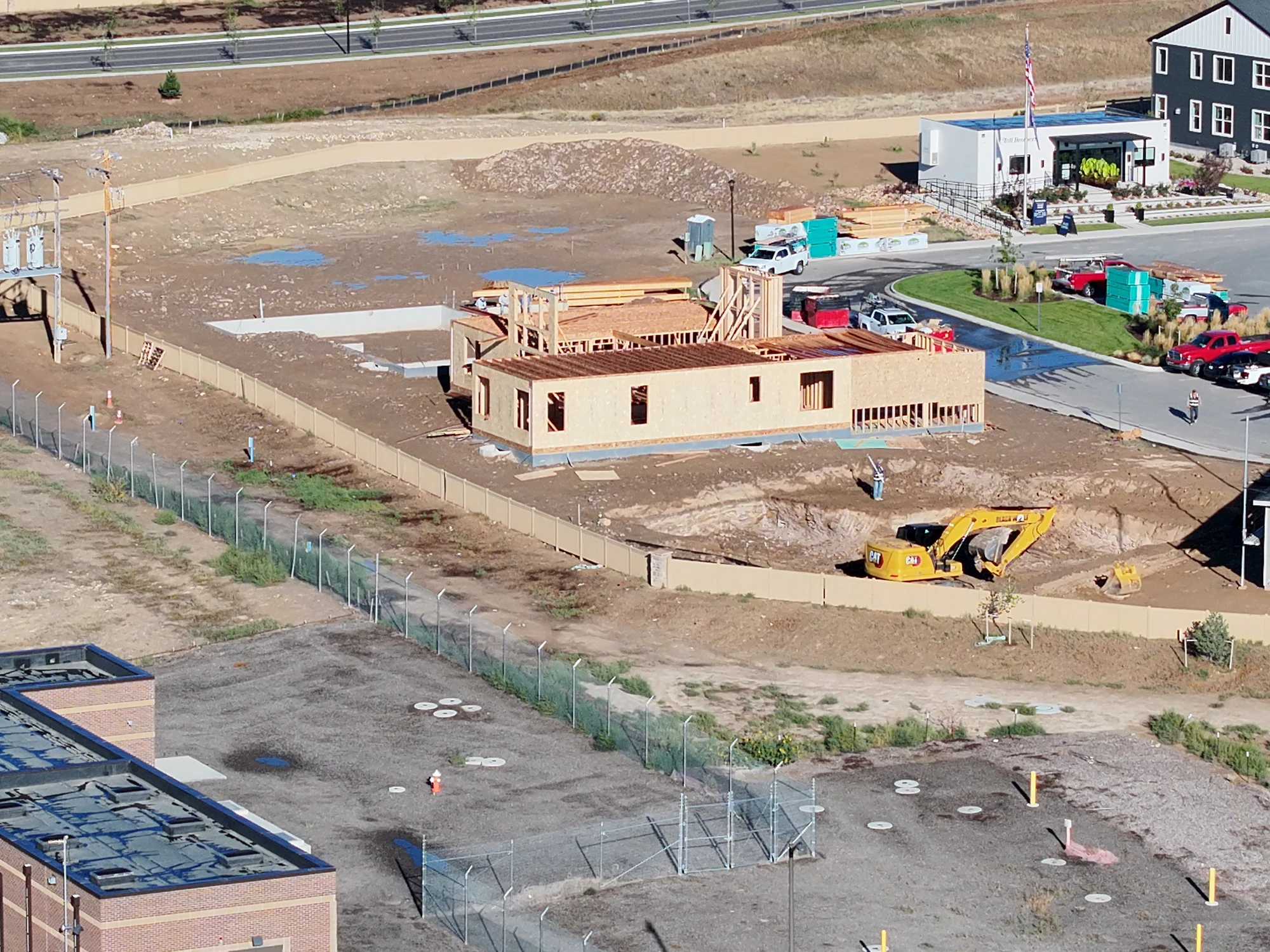 September 21 closer aerial view of active wall and floor framing with nearby foundations and excavation
