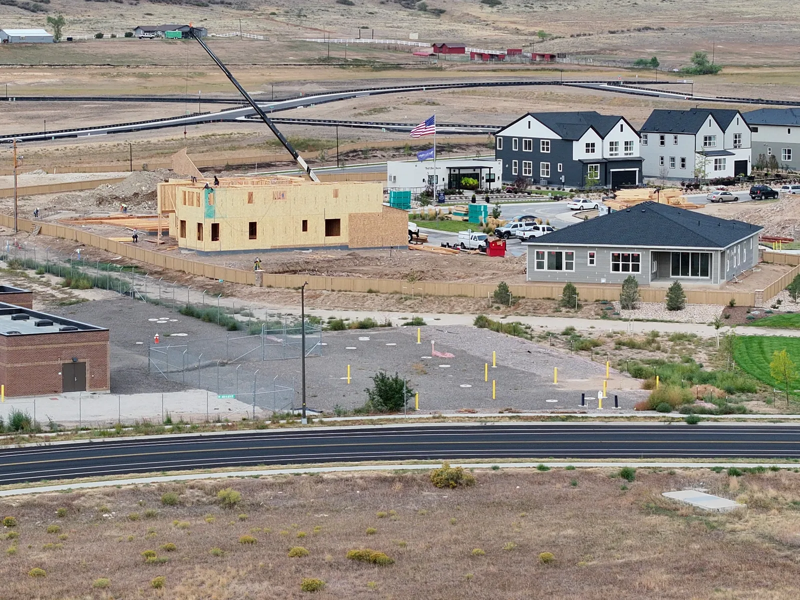 Residential construction site overview on September 28, 2026, showing wall sheathing and crane activity