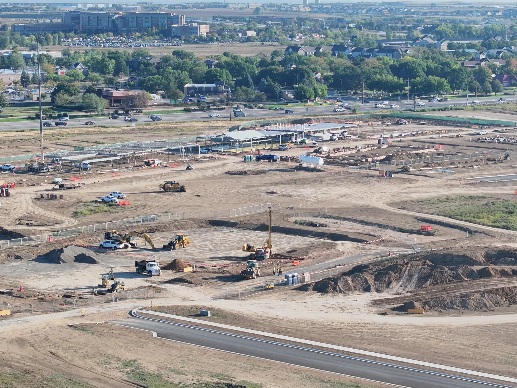 September 22 aerial overview of the commercial construction site, steel buildings, earthwork and surrounding neighborhood